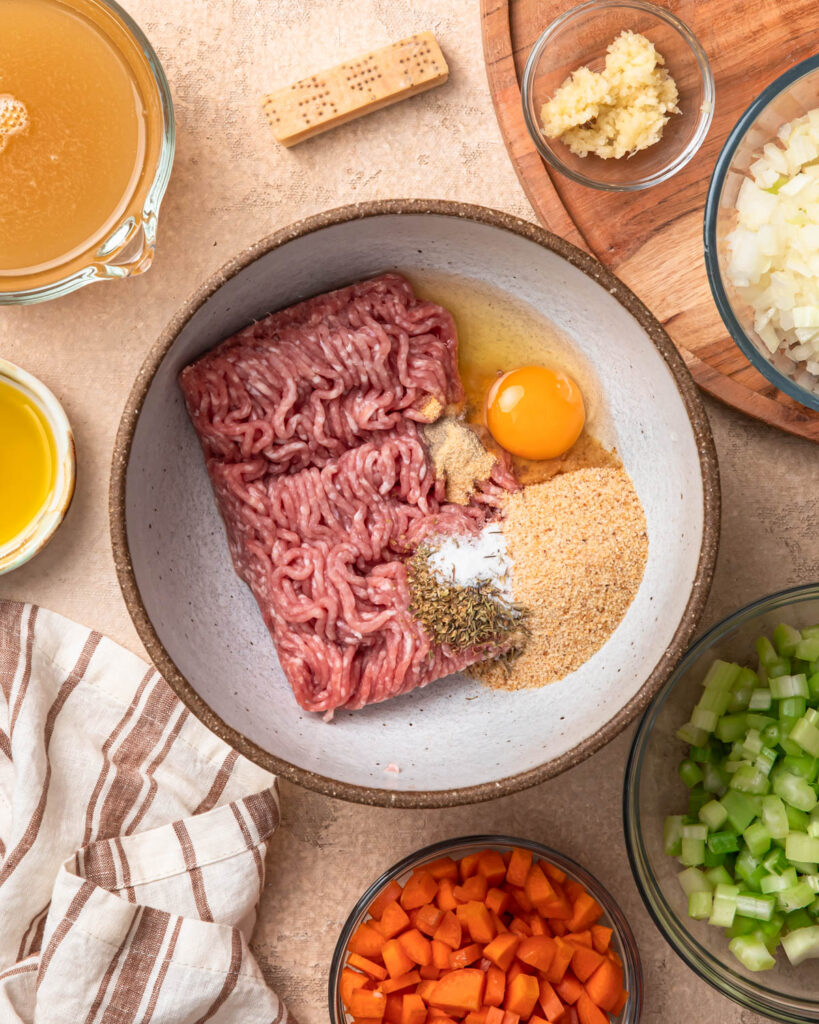 All of the ingredients for pork meatballs in a mixing bowl.
