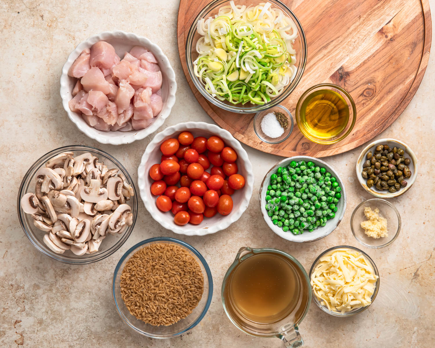 Ingredients for one pan chicken orzo pasta bake laid out in individual bowls.