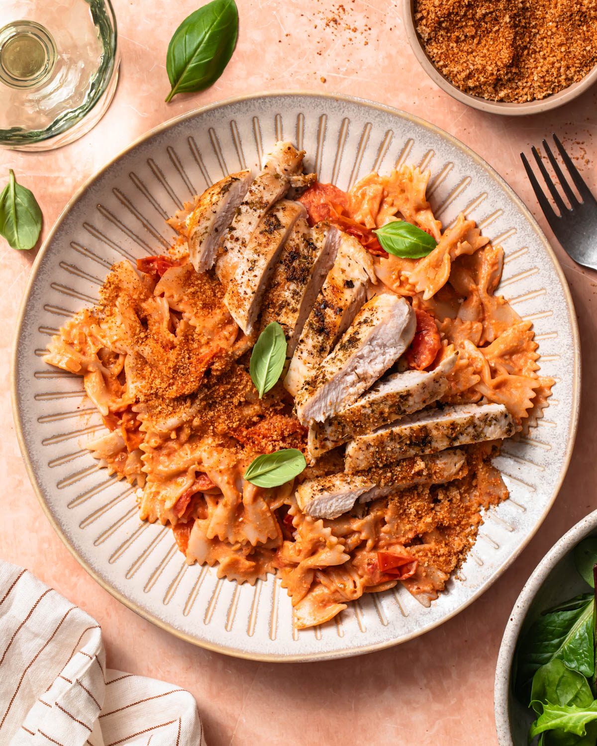 Bowl of chicken tomato goat's cheese pasta topped with fresh basil.