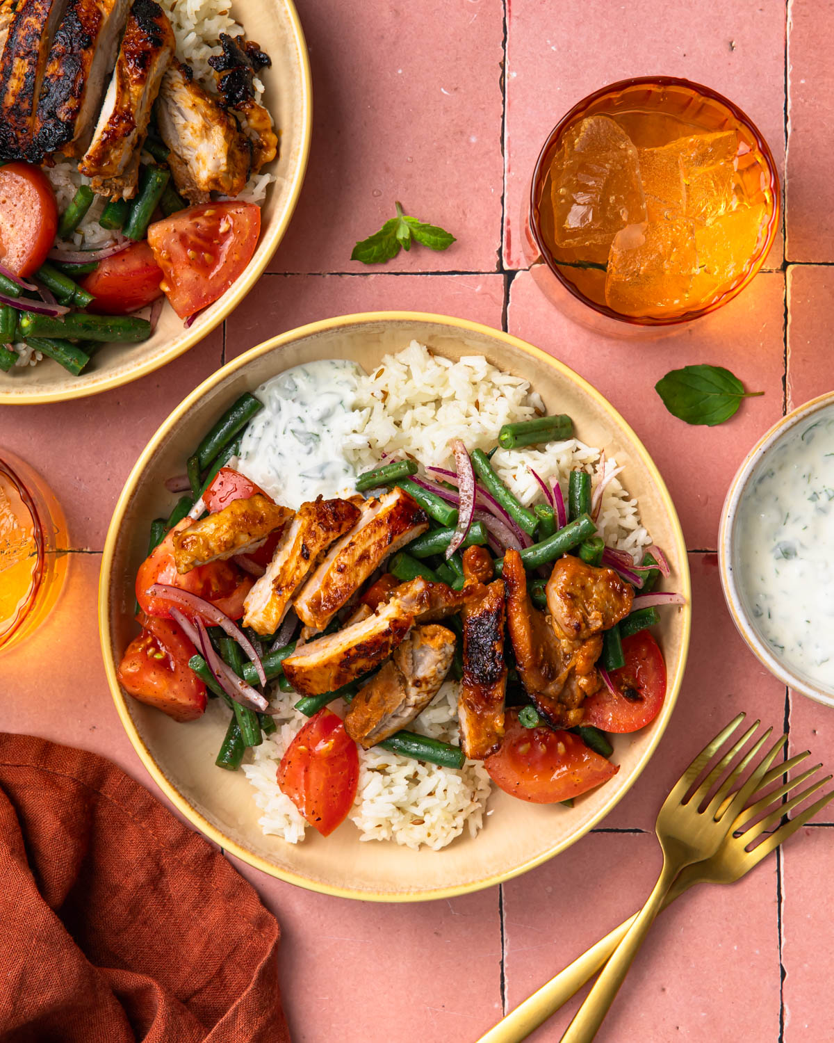 Two harissa chicken bowls, both served with rice and veggies.