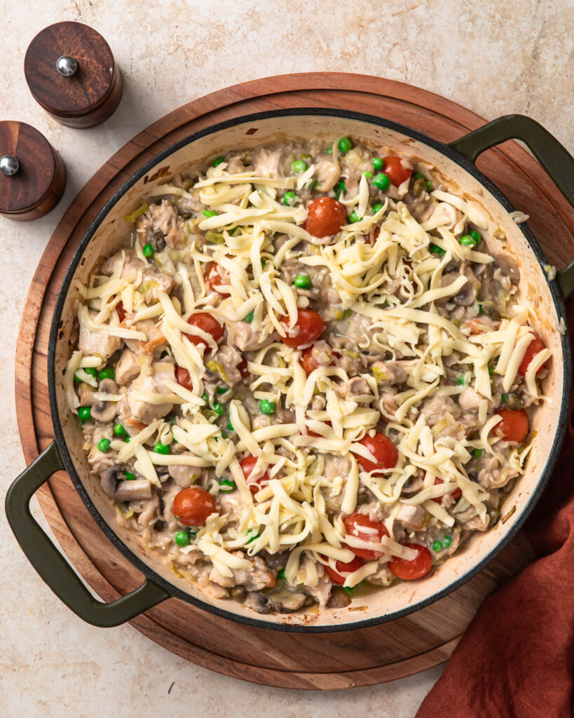 Chicken orzo pasta bake topped with shredded mozzarella.