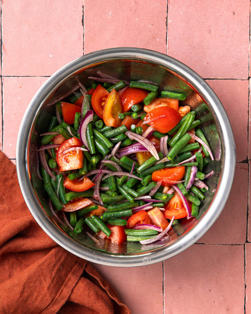 Sumac bean salad mixed together in a mixing bowl.