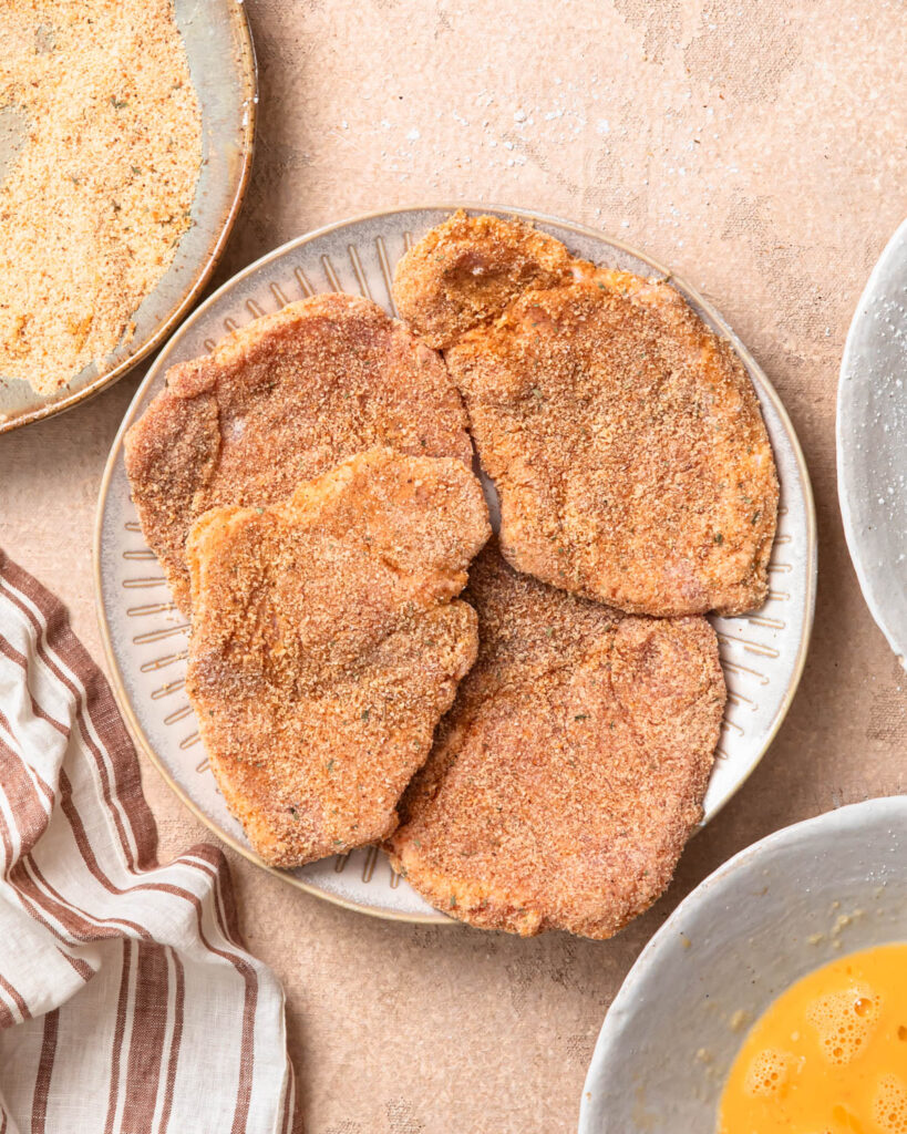 Crumbed pork cutlets on a plate.