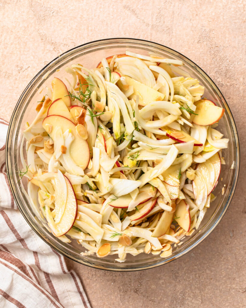 Apple and fennel slaw mixed together in a bowl.