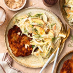 Pork schnitzel with apple fennel slaw on a plate.