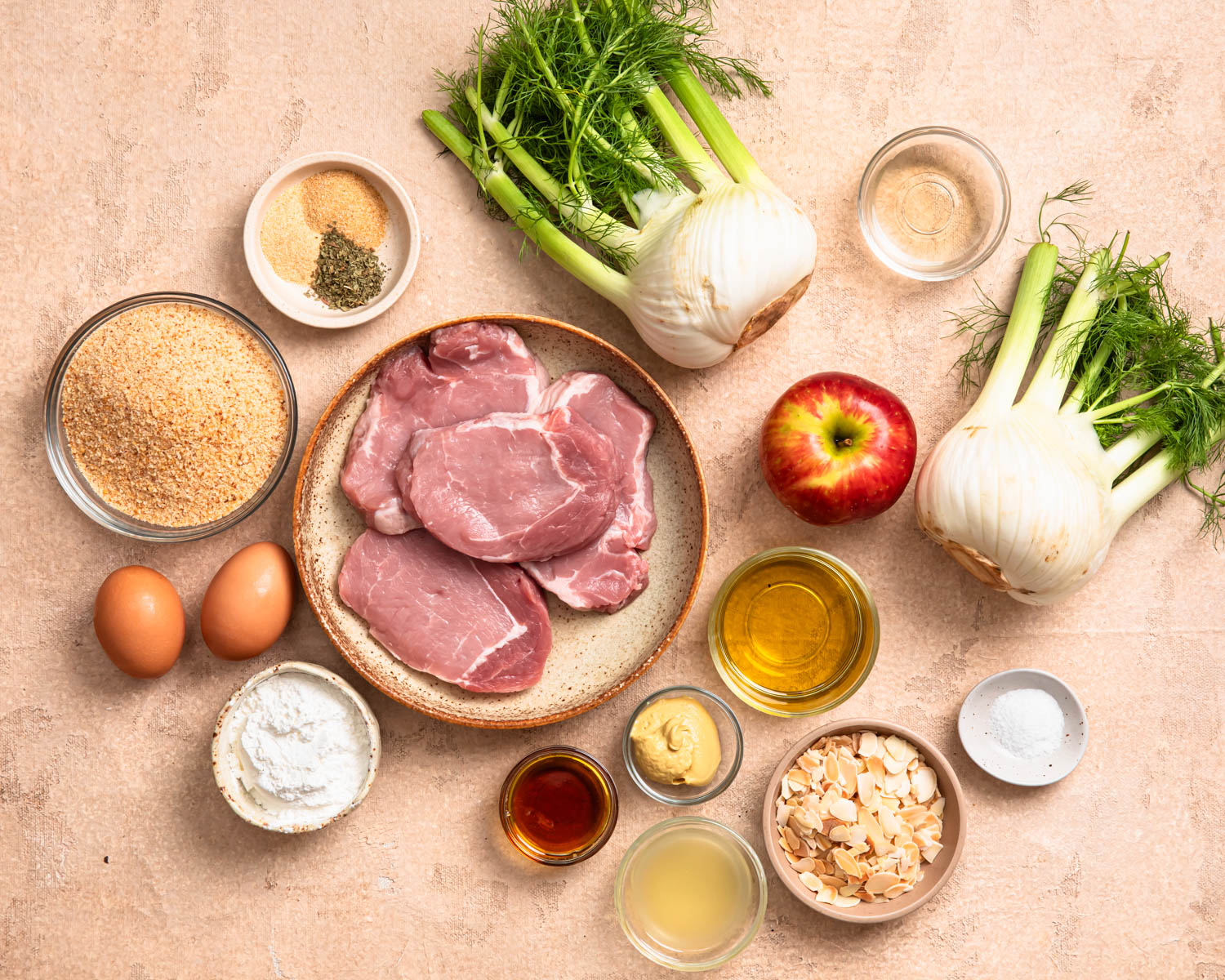 Ingredients needed to make Pork Schnitzel with Apple Fennel Slaw, all laid out in individual bowls.