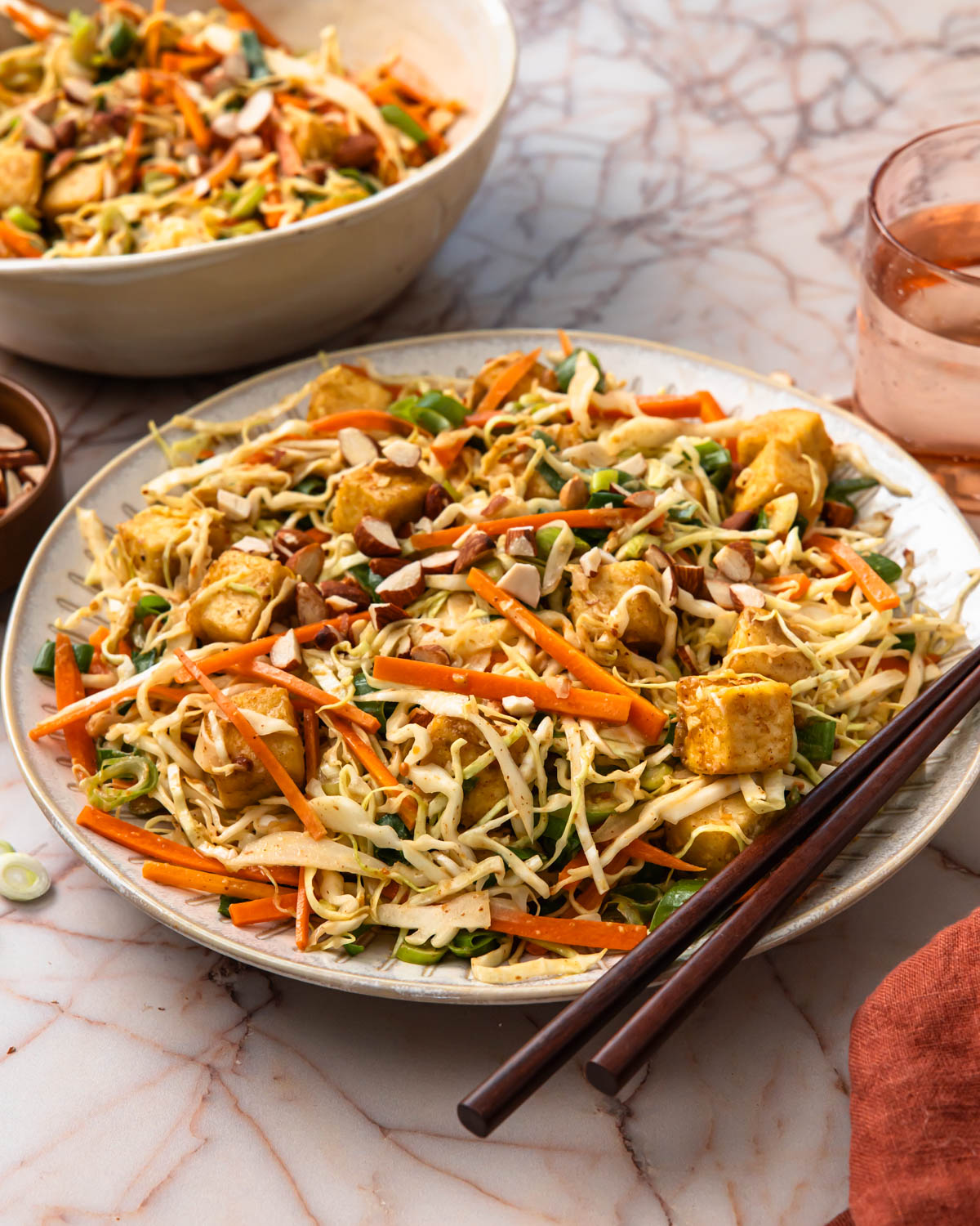 Side view of crunchy tofu salad in a bowl with chopsticks.