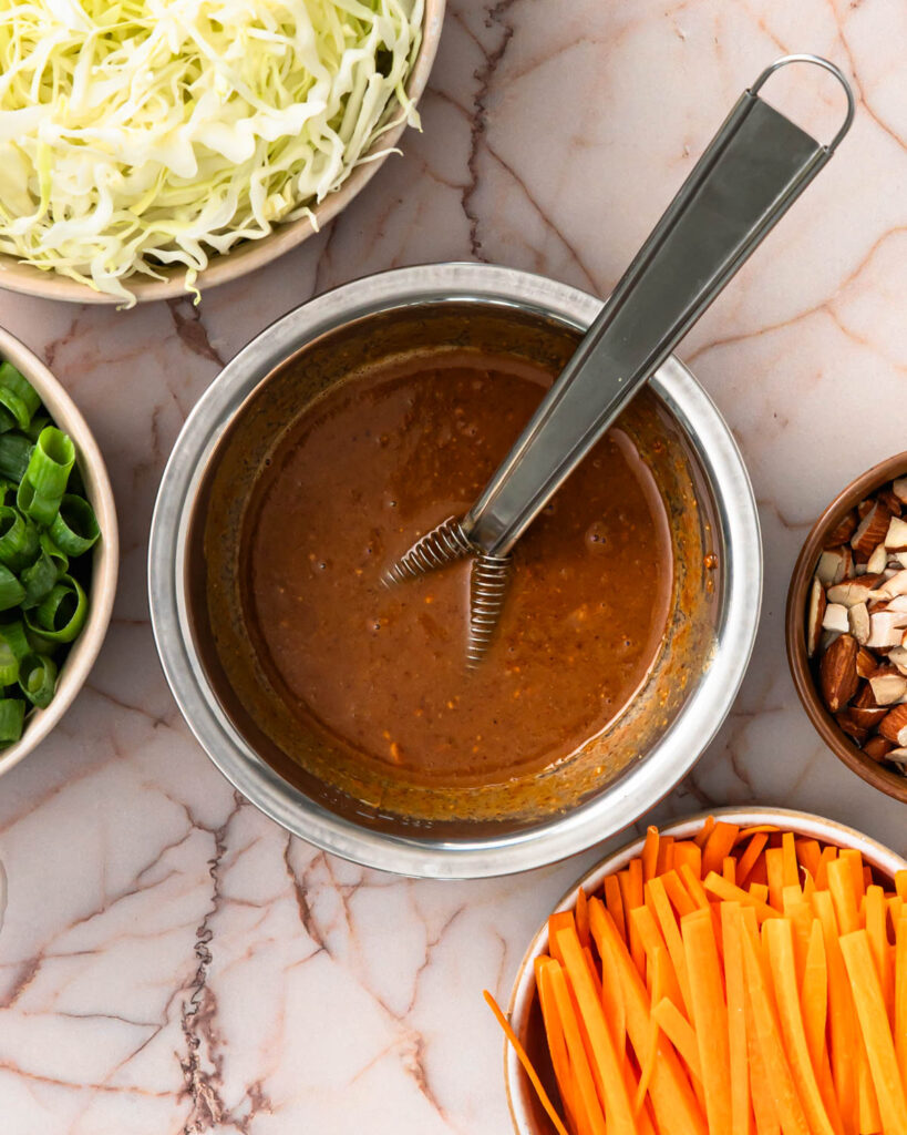 Whisking together the tofu salad dressing in a small bowl.
