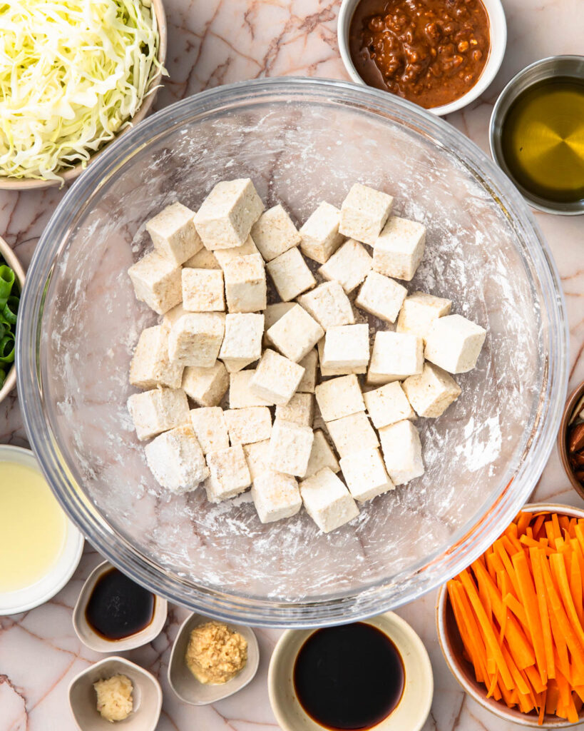 Tofu cubes coated in tapioca starch and spices in a bowl.