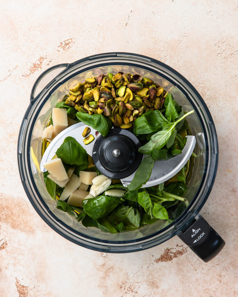 Pistachio pesto ingredients in a food processor before blending.
