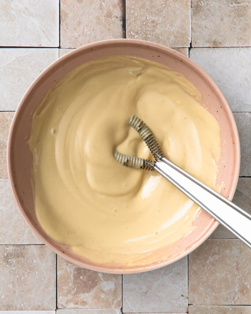 Tahini caesar dressing mixed together in a small bowl.