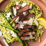 Pistachio pesto pasta served with asparagus and sliced lamb.