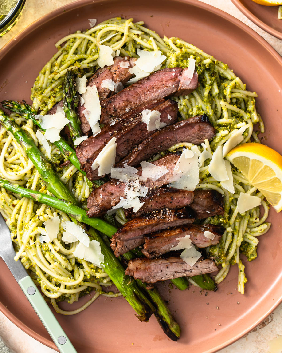 Pistachio pesto pasta served with asparagus and sliced lamb.