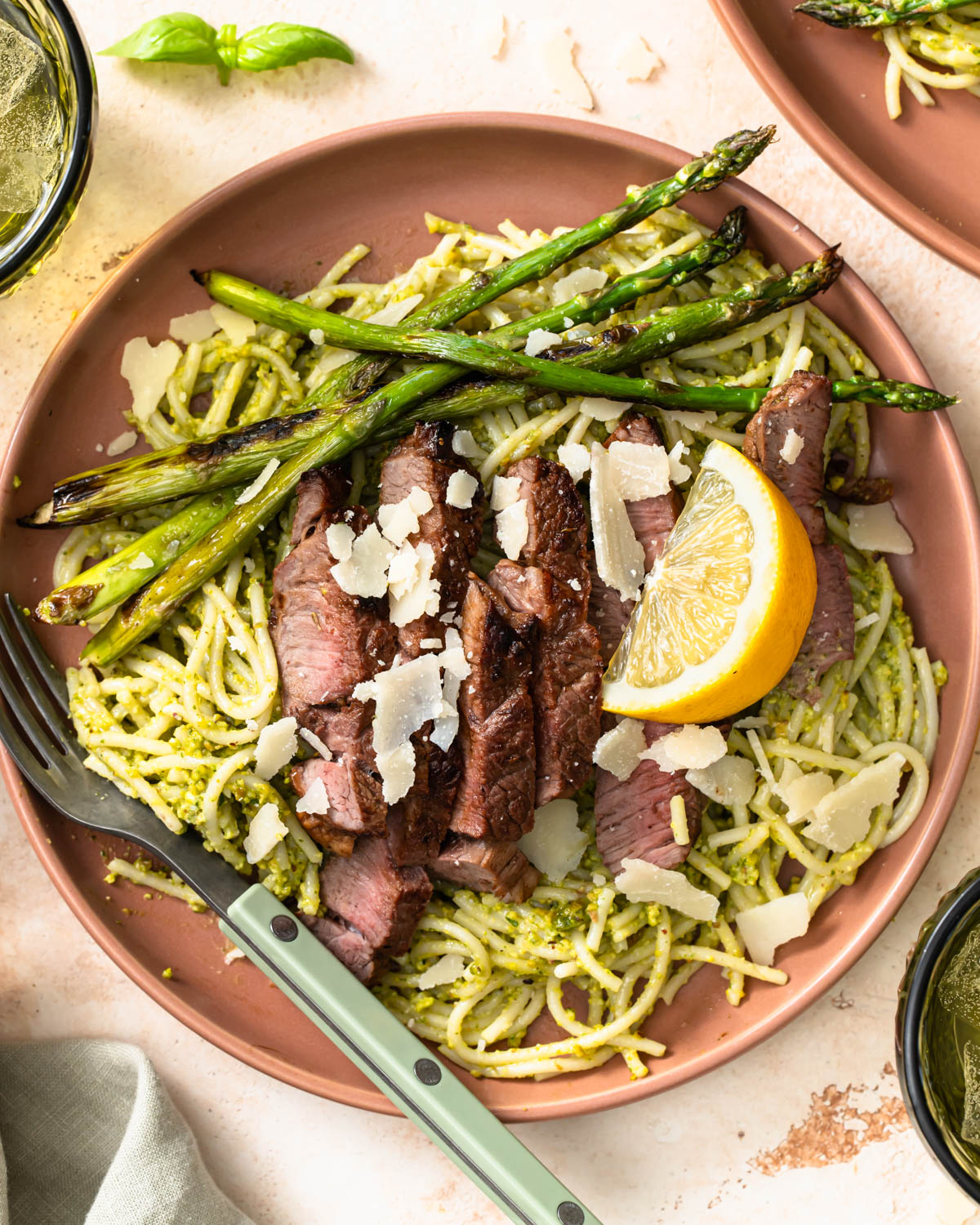 Asparagus and sliced lamb served on a bed of pistachio pesto pasta.