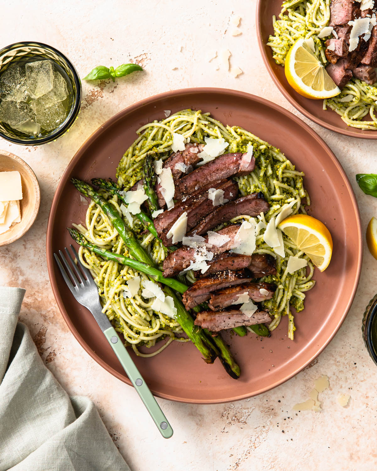 Pistachio pesto pasta served on a plate with lamb rump and asparagus.