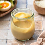 Side view of a jar of tahini caesar dressing.