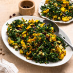 Cauliflower lentil salad on a serving dish with more on a plate behind it.