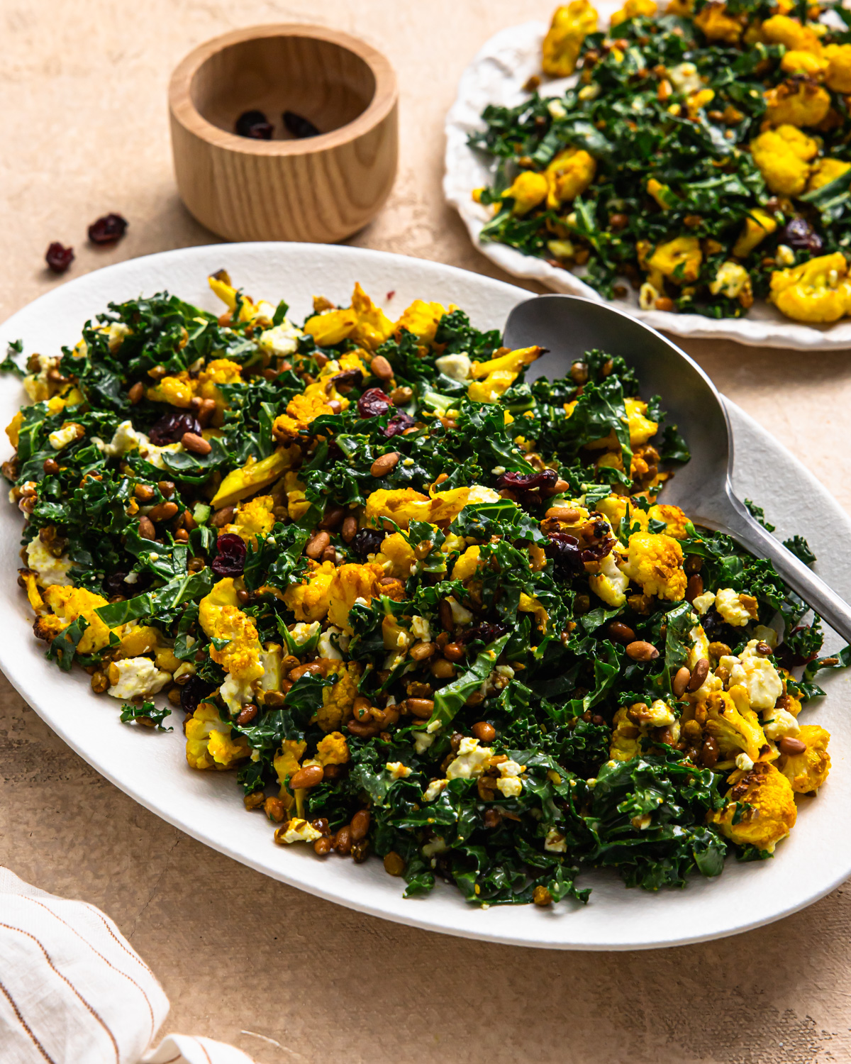 Cauliflower lentil salad on a serving platter with a serving spoon.