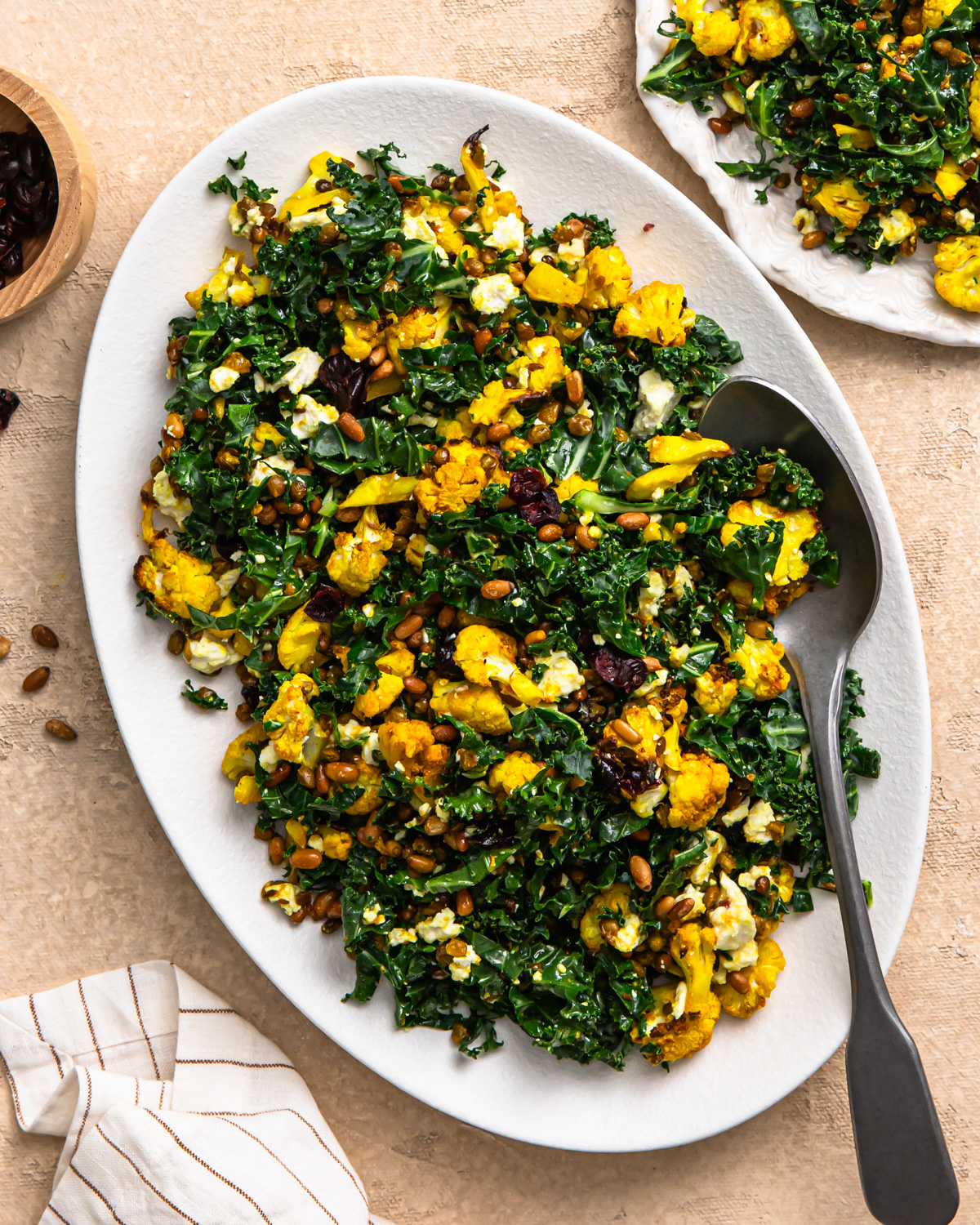 Overhead shot of cauliflower lentil salad on a serving dish with a spoon.