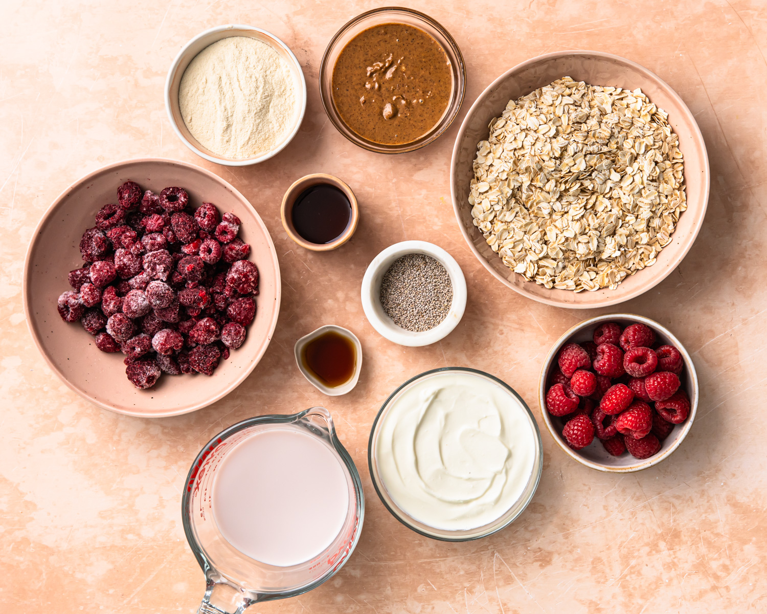 Ingredients for high protein overnight oats laid out in individual bowls.