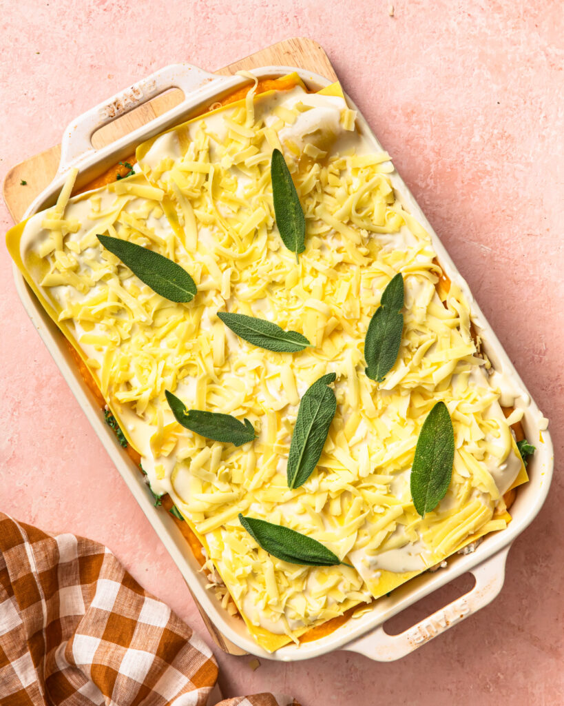 An assembled but unbaked butternut squash lasagne in a baking dish.