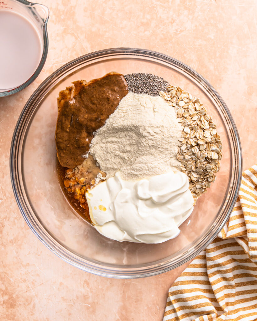 Ingredients for high protein overnight oats in a mixing bowl.
