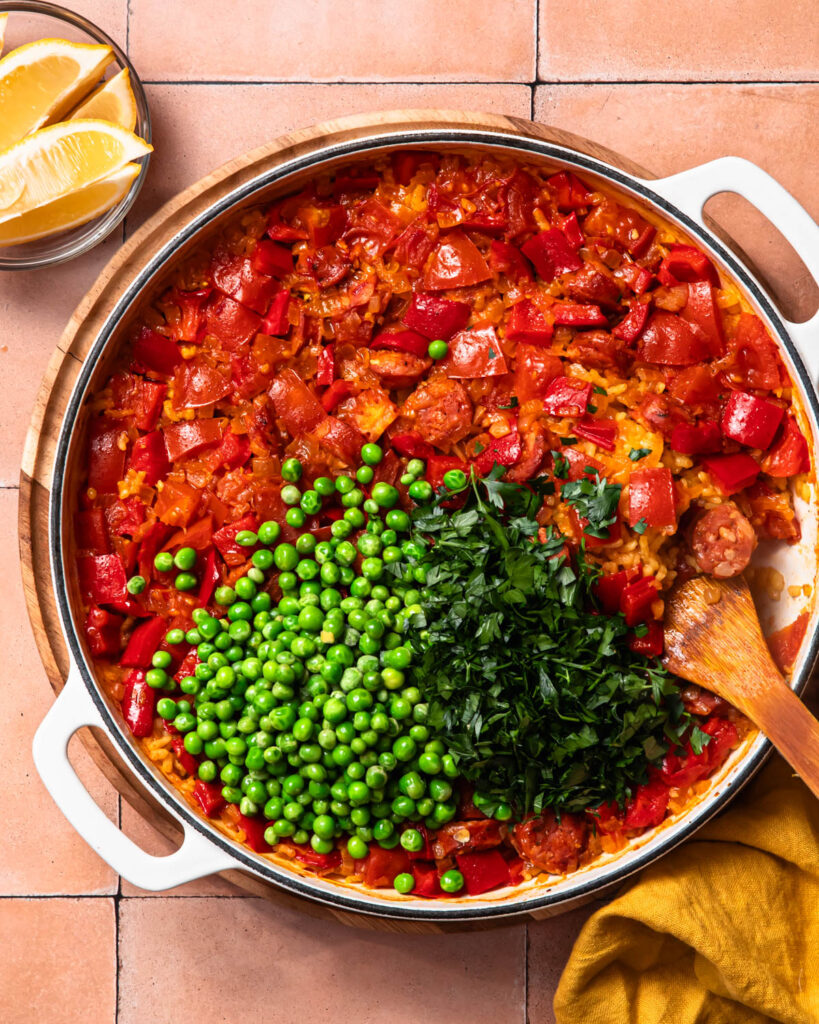 Peas and parsly added to the baked paella.
