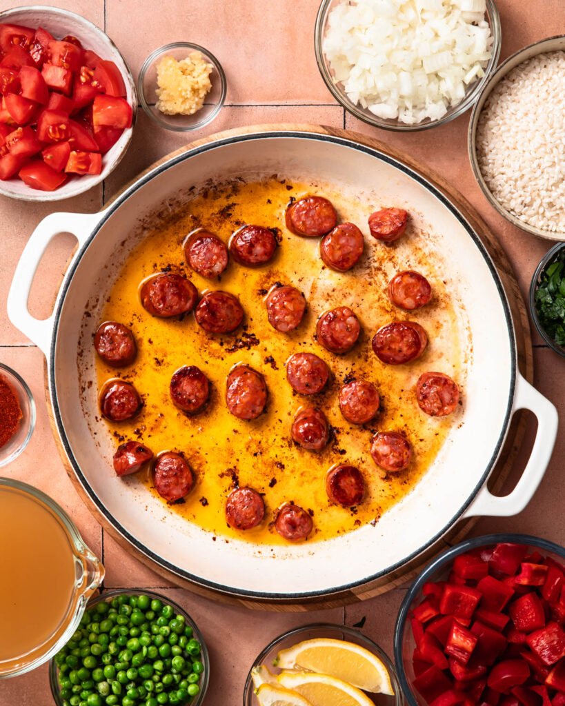 Searing Spanish chorizo in a skillet.