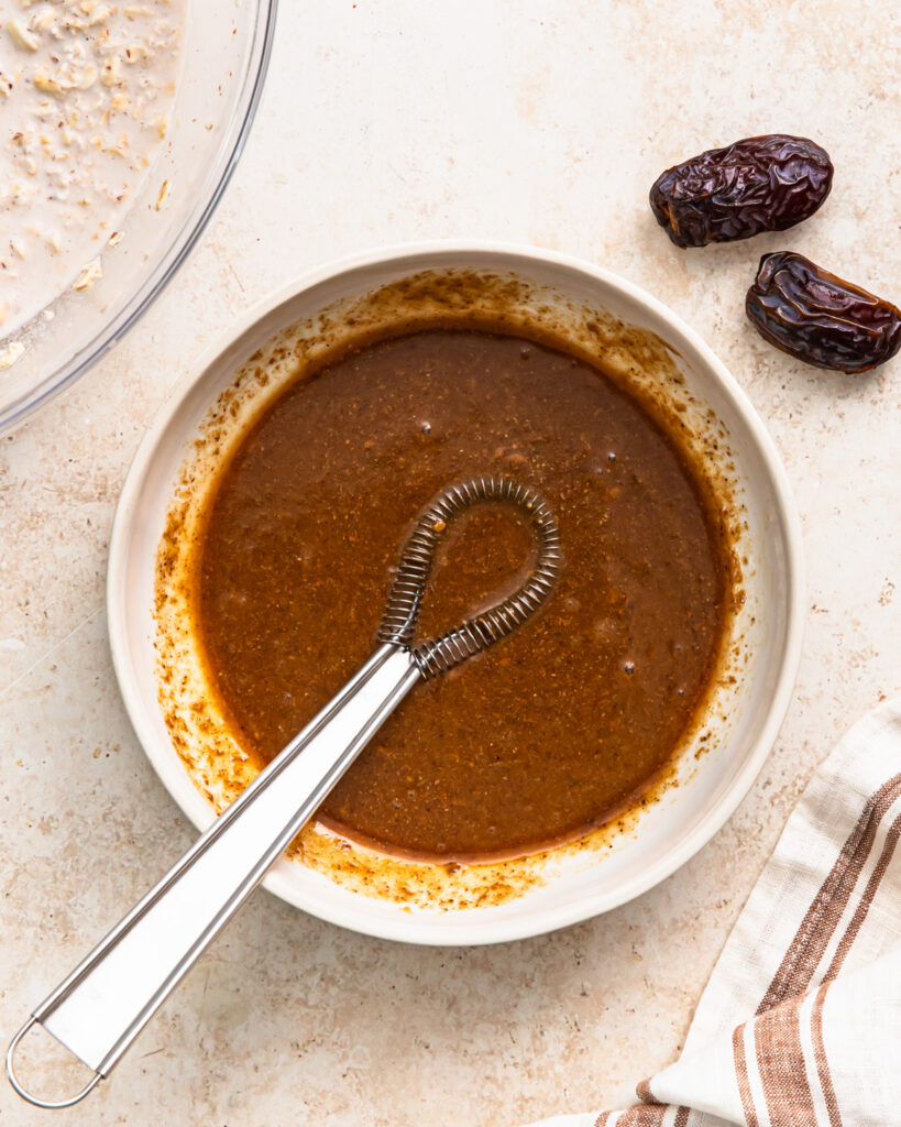Almond butter, vanilla extract, maple syrup, and salt whisked together in a bowl.