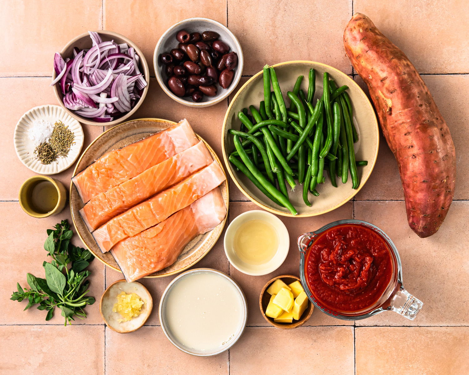 Ingredients needed to make salmon puttanesca laid out in individual bowls. 