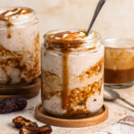 Side view of sticky date overnight oats in a jar with another jar in the background.