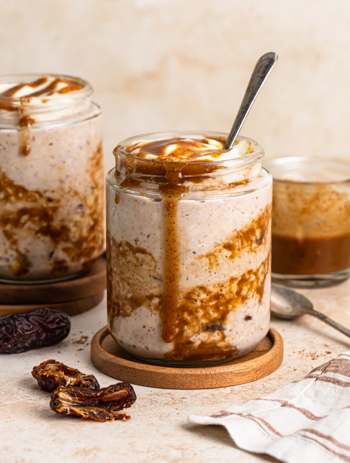 Side view of sticky date overnight oats in a jar with another jar in the background.